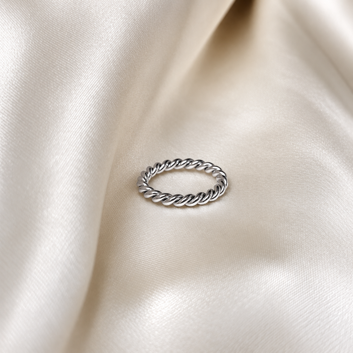 Milly Moon Ring i silver fotograferad på ljust silkestyg. Vattentåligt och allergivänligt smycke i rostfritt stål från Alora Avenue.