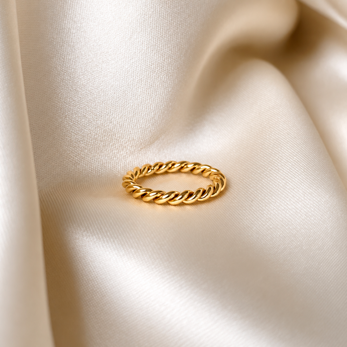 Minnie Moon Ring i guld fotograferad på ljust silkestyg. Vattentåligt och allergivänligt smycke i rostfritt stål med 18K PVD-guldplätering från Alora Avenue.