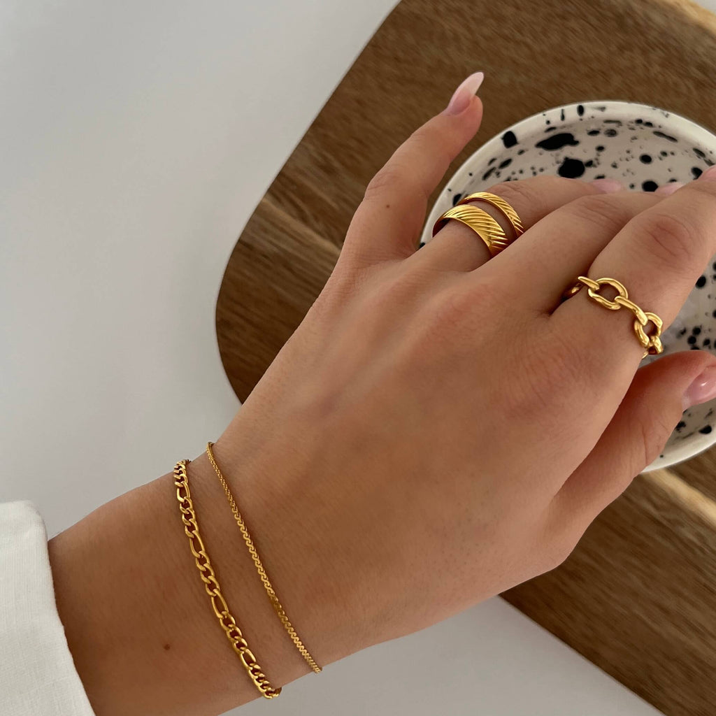 Oblique Olive Ring från Alora Avenue – en guldfärgad ring med snedräfflad yta i mellanbred modell. Perfekt balans mellan statement och vardagsklassiker, snygg att bära solo eller i kombination med andra ringar.