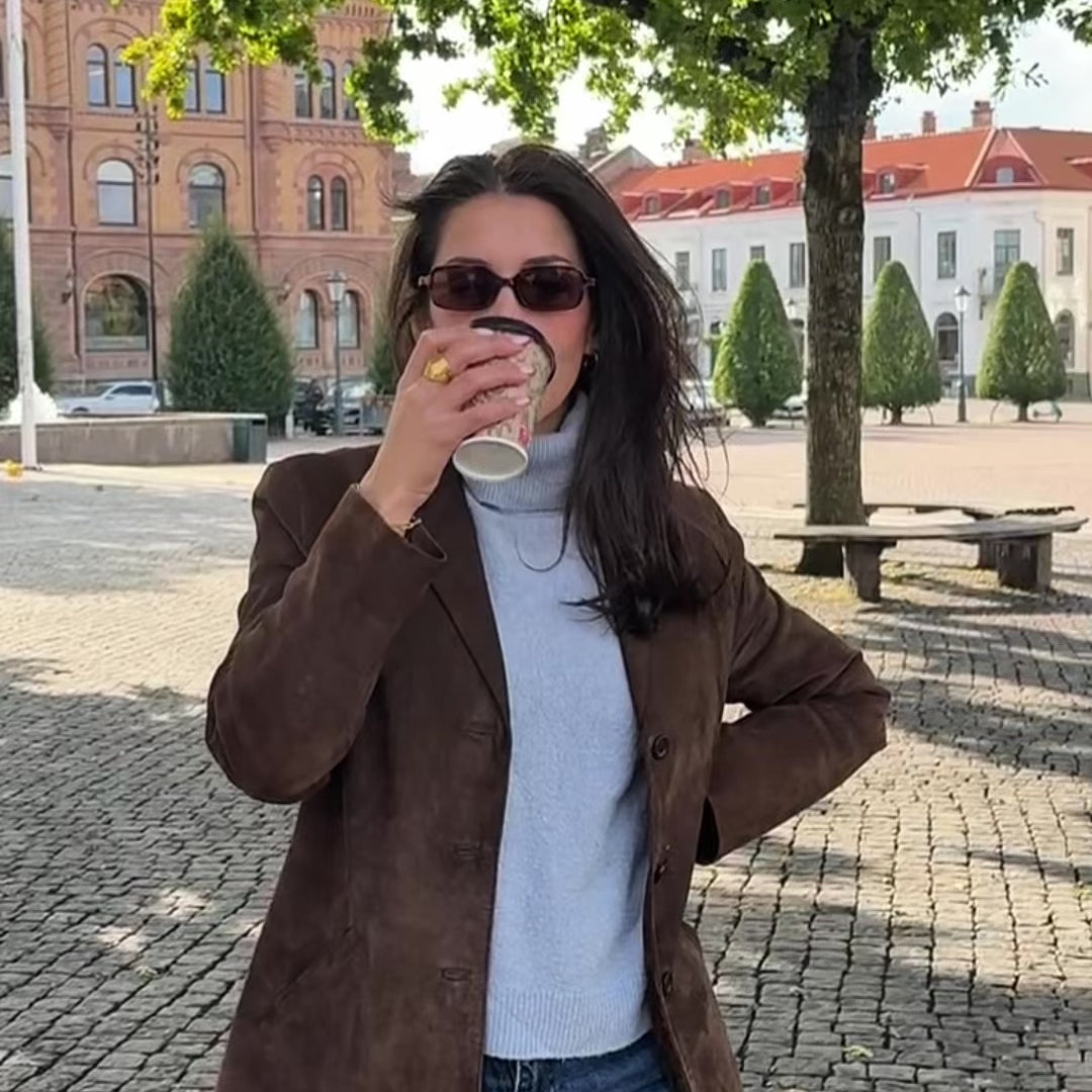 Kvinna bär vattentåliga guldsmycken i rostfritt stål från Alora Avenue – tidlösa halsband, örhängen och armband designade för vardag, dusch och hav.