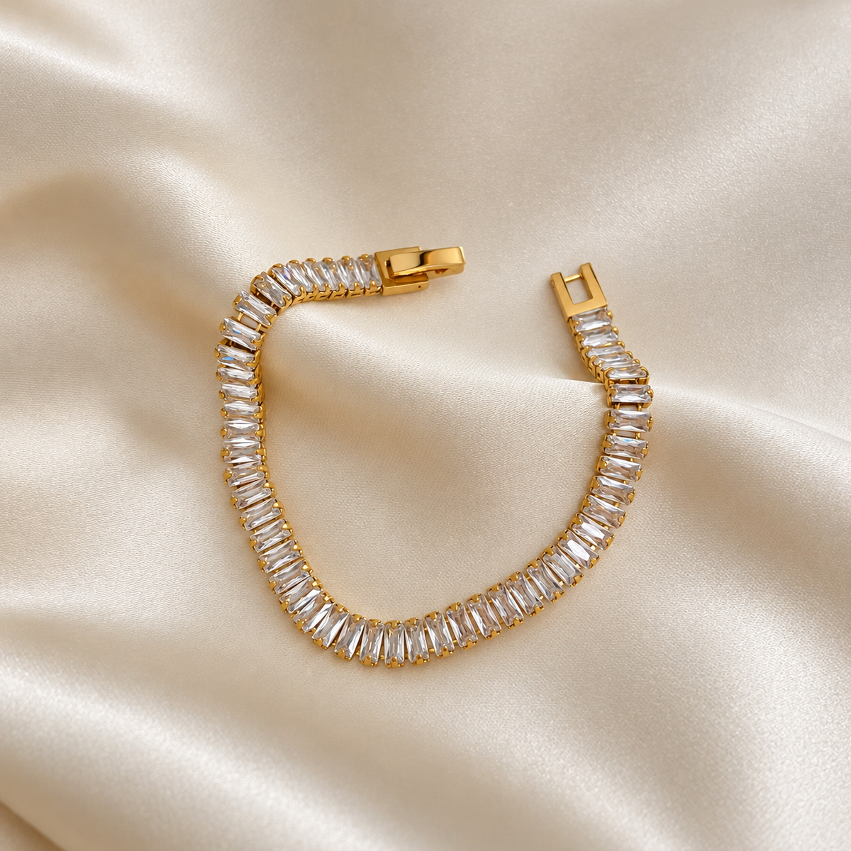Santiago Sunstone Bracelet i guld fotograferat på ljust silkestyg. Vattentåligt och allergivänligt armband i rostfritt stål med 18K PVD-guldplätering från Alora Avenue.