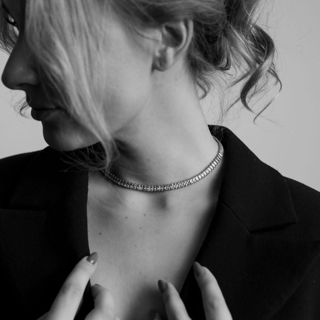 Sienna Sunstone Necklace – guldigt choker-halsband med vita gnistrande stenar, fotograferat i svartvitt för en tidlös och elegant känsla från Alora Avenue