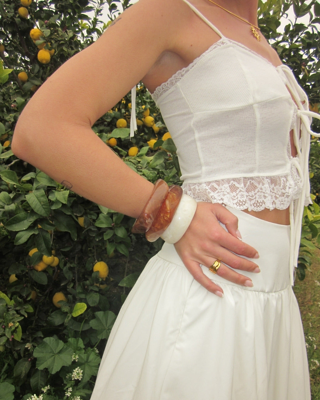 Solana Sun Necklace och Costa Bangles med vit topp bland citronträd – Alora Avenue