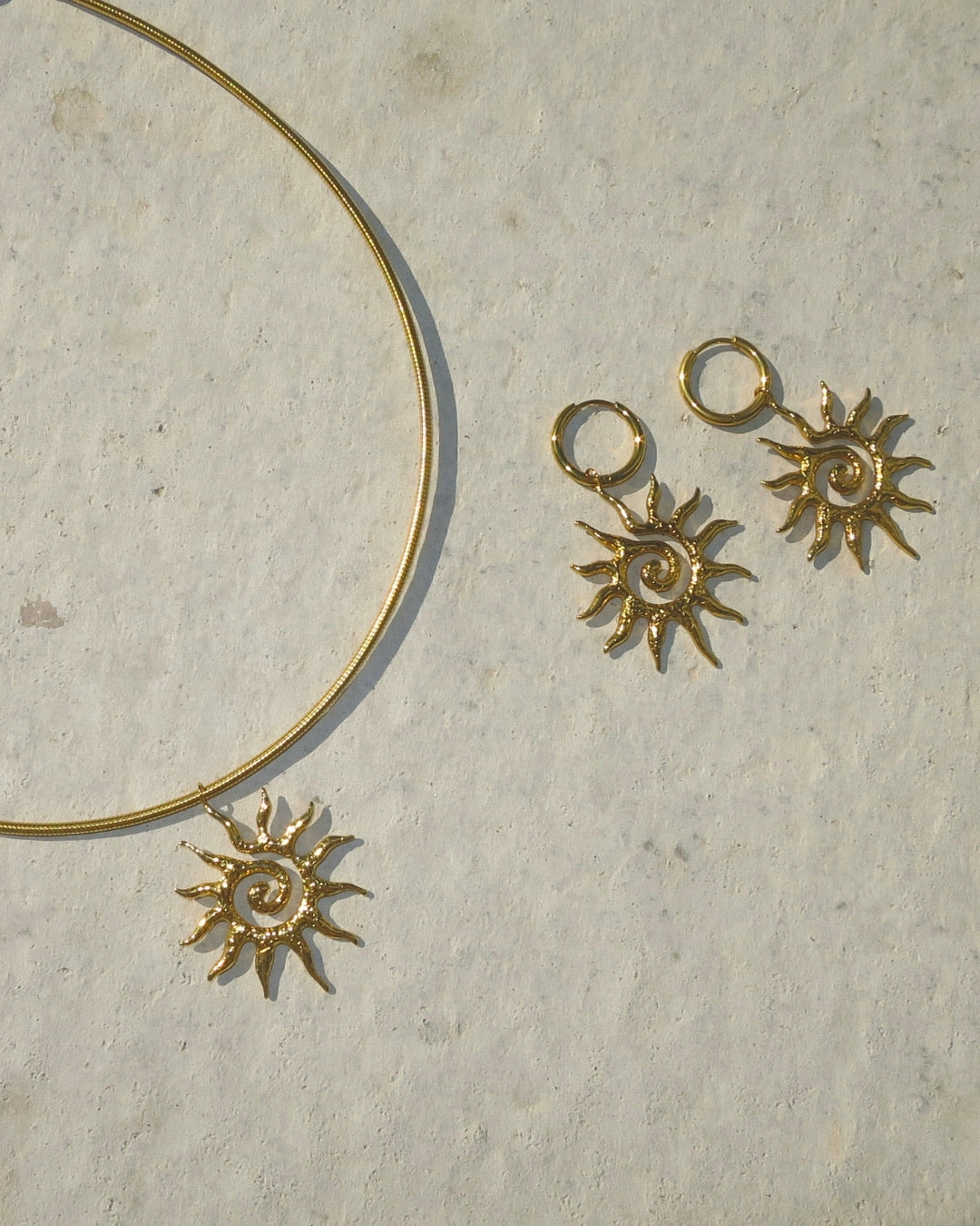 Solana Sun Necklace och Solana Sun Earrings i guld – flatlay produktbild Alora Avenue