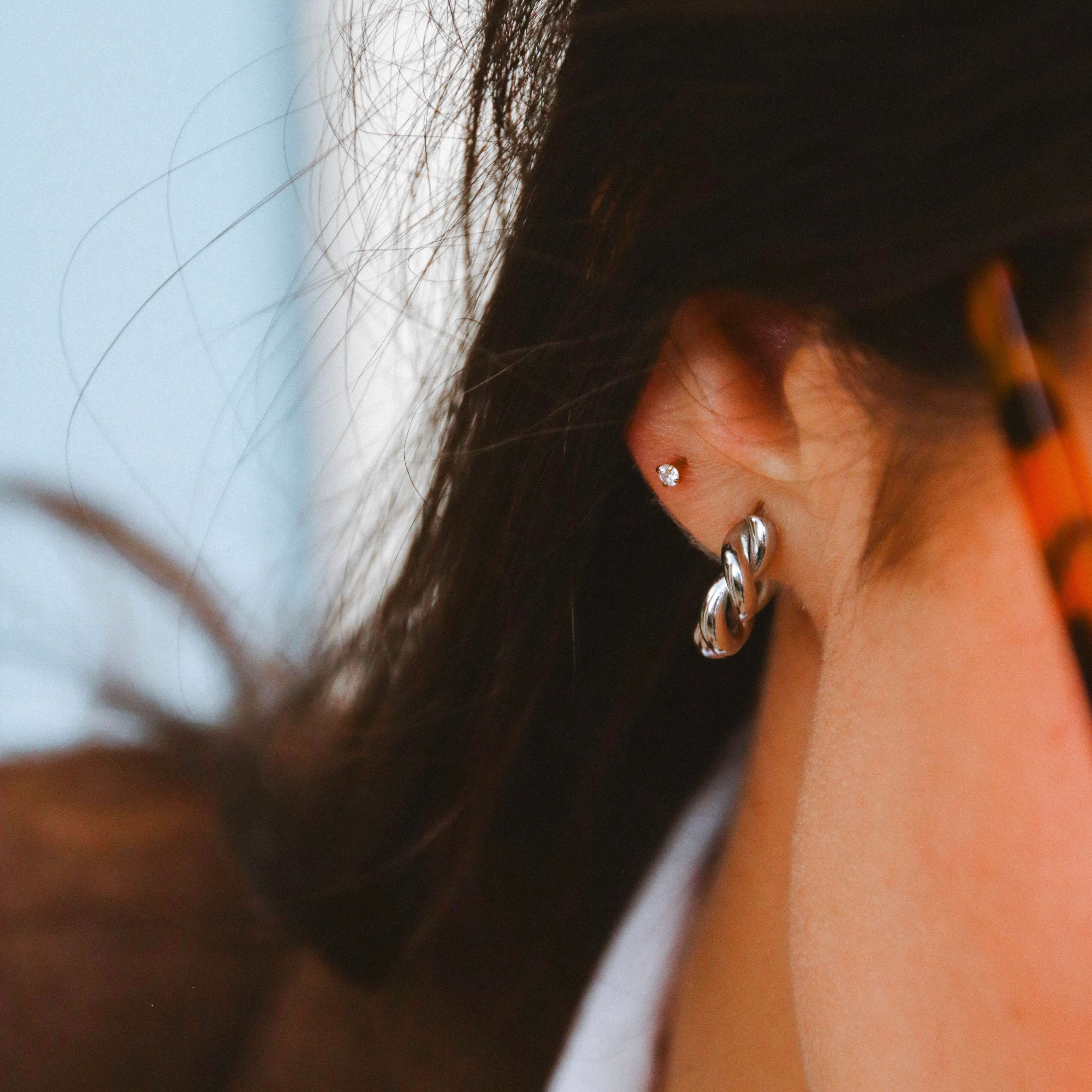 Tornado Edge Earrings i silver från Alora Avenue – snurrade, vattentåliga hoops med elegant form och modern glans som lyfter varje vardagslook.
