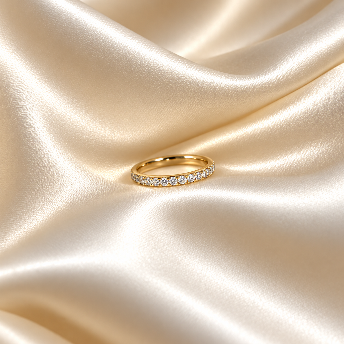 Twinkle Tara Ring i guld fotograferad på ljust silkestyg. Vattentåligt och allergivänligt smycke i rostfritt stål med 18K PVD-guldplätering från Alora Avenue.