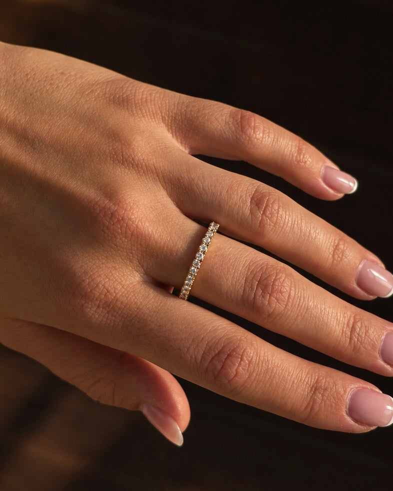 Twinkle Tara Ring i guld buren på modell – smal ring med en rad gnistrande cubic zirconia. Vattentålig ring i rostfritt stål med 18K guldplätering från Alora Avenue.