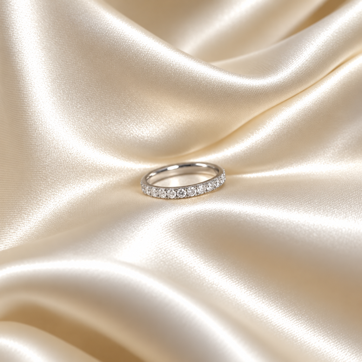 Twinkle Thea Ring i silver fotograferad på ljust silkestyg. Vattentåligt och allergivänligt smycke i rostfritt stål från Alora Avenue.