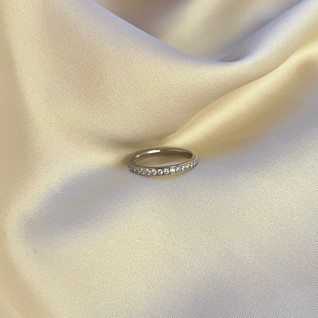 Twinkle Thea Ring – stilren silverfärgad ring med gnistrande stenar runt hela bandet. Perfekt som statementring eller att stapla med andra smycken. Vattentålig och allergivänlig – tillverkad i rostfritt stål med PVD-plätering för extra hållbarhet.