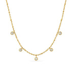 Vera V Necklace i guld med fem gnistrande vita stenar, fotat mot vit bakgrund. Tunt och elegant halsband från Alora Avenue – vattentåligt, allergivänligt och perfekt för layering.