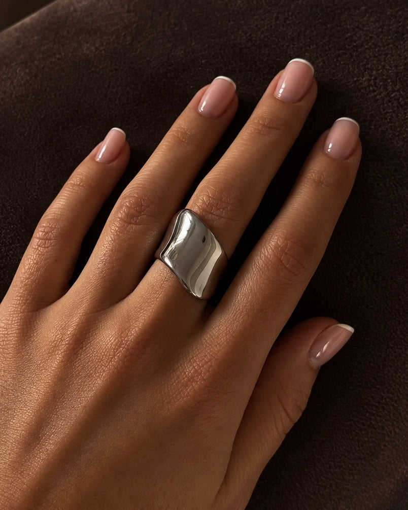 Verbena Volume Ring i silver buren på modell – bred, skulpterad chunky ring med vågig, högblank yta. Vattentålig, allergivänlig ring i rostfritt stål från Alora Avenue.